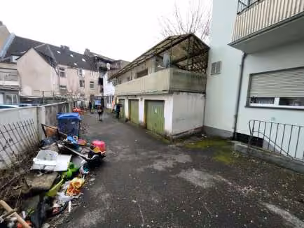 Zwangsversteigerung Büro in Leverkusen, Opladen – Hofansicht mit Garagentoren und Anbauten.