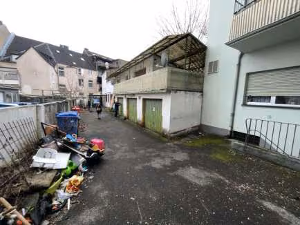Zwangsversteigerung Büro in Leverkusen, Opladen – Hofansicht mit Garagentoren und Anbauten.