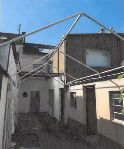 Zwangsversteigerung Reihenhaus in Düren, Arnoldsweiler – Rückansicht des Gebäudes und Hofbereichs mit Anbau.