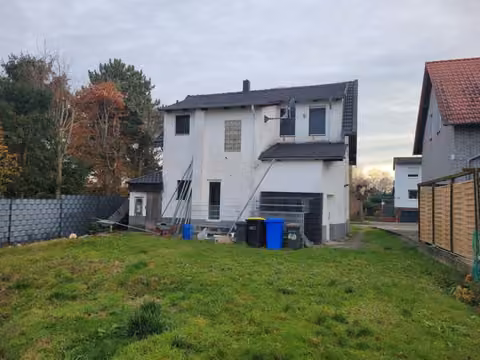 Zwangsversteigerung Einfamilienhaus in Bad Oeynhausen, Kernstadtbereich – Westansicht des Wohnhauses mit Anbau und Gartenbereich.