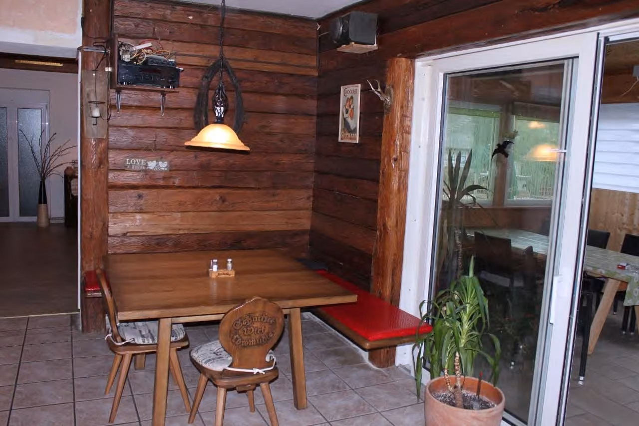 Zwangsversteigerung Einfamilienhaus in Thyrnau, Löwmühle – Gastraum der Gaststätte mit Holzverkleidung und Bestuhlung.