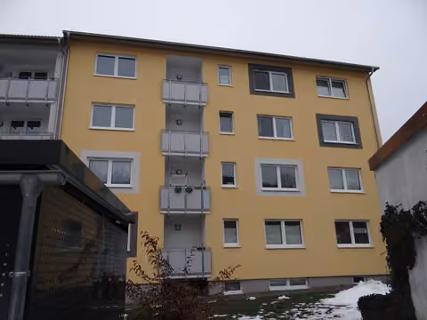 Zwangsversteigerung Eigentumswohnung in Bad Brückenau – Außenansicht des Mehrfamilienhauses Berliner Platz 10 von der Zugangsseite.