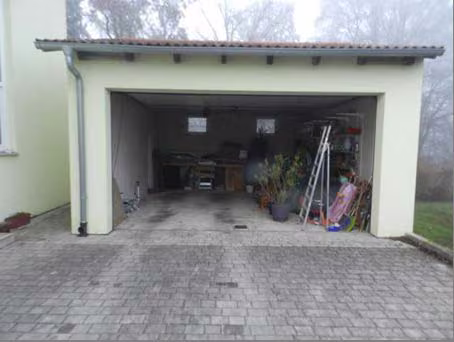 Zwangsversteigerung Einfamilienhaus in Parsberg – Doppelgarage von der Zufahrtsseite mit geöffnetem Sektionaltor.