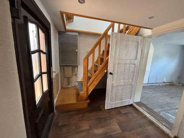 Zwangsversteigerung Einfamilienhaus in Siedenbollentin – Flurbereich im Erdgeschoss mit Holztreppe zum Dachgeschoss.