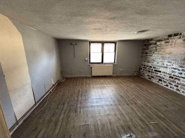 Zwangsversteigerung Einfamilienhaus in Siedenbollentin – Wohnzimmer im Erdgeschoss mit Dielenboden und verputzten Wänden.