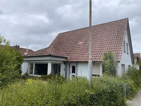 Zwangsversteigerung Einfamilienhaus in Wittmund, Carolinensiel – Vorderansicht des Wohnhauses mit Vorgarten und Eingangsbereich.