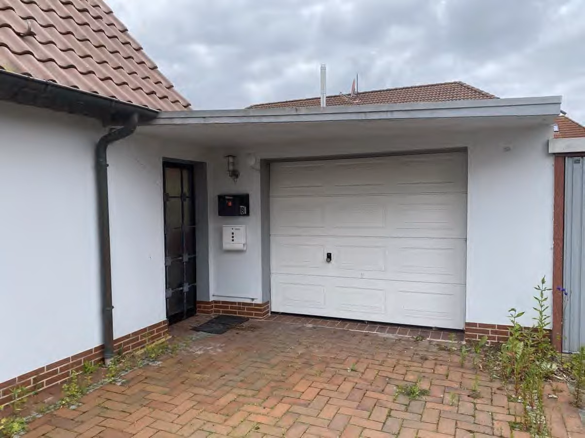 Zwangsversteigerung Einfamilienhaus in Wittmund, Carolinensiel – Massives Nebengebäude mit Garage und Zufahrt.