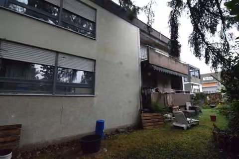 Zwangsversteigerung Eigentumswohnung in Mutlangen – Außenansicht des Hinterhauses mit Erdgeschosswohnung und vorgelagerter Terrasse.
