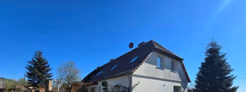 Zwangsversteigerung Einfamilienhaus in Demmin, Lindenfelde – Blick auf den Westgiebel der Doppelhaushälfte und die gepflasterte Hofzufahrt.