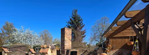 Zwangsversteigerung Einfamilienhaus in Demmin, Lindenfelde – Großzügige Terrasse mit Bruchsteinpflaster, Pergola und gemauertem Grillkamin.