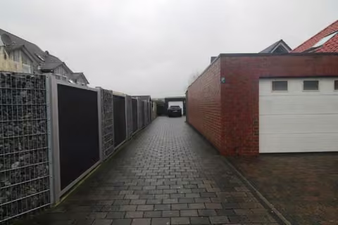 Zwangsversteigerung Einfamilienhaus in Nottuln, Appelhülsen – Blick entlang der gepflasterten Zufahrt zum Erbbaurechtsgrundstück.