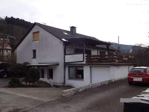 Zwangsversteigerung Einfamilienhaus in Werdohl, Kettling – Vorderansicht des Wohn- und Gewerbegebäudes mit Garagentrakt von der Gewerbestraße.