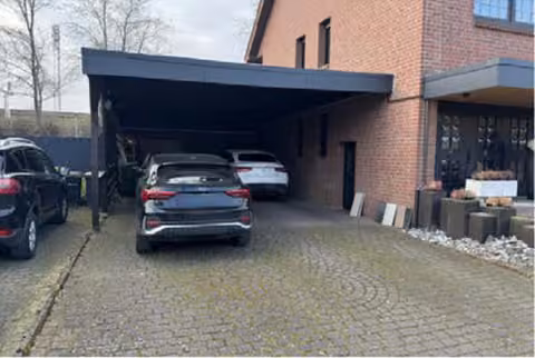 Zwangsversteigerung Eigentumswohnung in Rheda-Wiedenbrück, Rheda – Zufahrt und Carport an der Nordseite des Hauses.