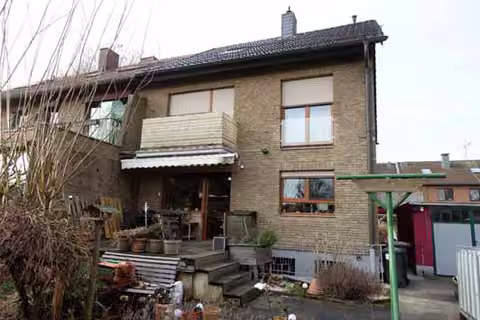 Zwangsversteigerung Doppelhaushälfte in Hürth, Efferen – Rückansicht des Wohnhauses mit Balkon und Gartenzugang.