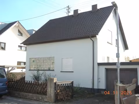 Zwangsversteigerung Einfamilienhaus in Heßheim – Straßenansicht des freistehenden Einfamilienhauses mit Giebel und Vorgarten aus nordwestlicher Richtung.