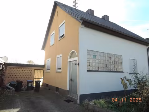 Zwangsversteigerung Einfamilienhaus in Heßheim – Ansicht der Hofeinfahrt und Giebelseite des Wohnhauses aus nordöstlicher Richtung.