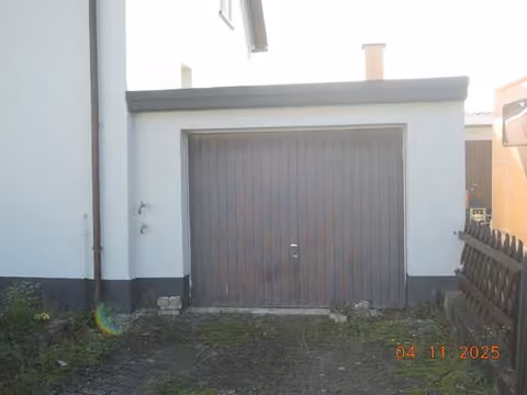 Zwangsversteigerung Einfamilienhaus in Heßheim – Außenansicht der angebauten massiven Garage mit Stahlschwingtor.