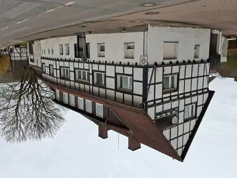 Zwangsversteigerung Mehrfamilienhaus in Bad Pyrmont, Holzhausen – Straßenansicht des Mehrfamilienhauses von Osten und Süden.