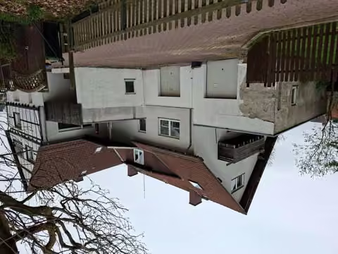 Zwangsversteigerung Mehrfamilienhaus in Bad Pyrmont, Holzhausen – Rück- und Hofansicht mit Garagenzufahrt von Südwesten.