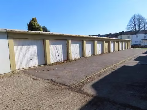 Zwangsversteigerung Grundstück in Alsdorf, Ofden – Vorderansicht der gesamten Garagenzeile entlang der asphaltierten Zufahrt.