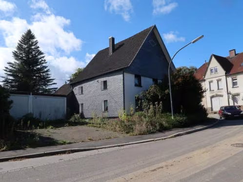Zwangsversteigerung Einfamilienhaus in Gevelsberg, Asbeck – Ansicht Norden mit Wohnhaus und Fertiggaragen