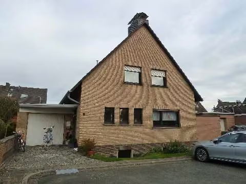 Zwangsversteigerung Einfamilienhaus in Grevenbroich, Neukirchen – Vorderansicht des freistehenden Einfamilienhauses mit Hauseingang und Vorgarten