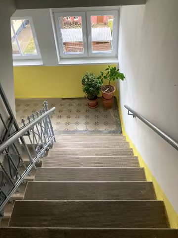 Zwangsversteigerung Eigentumswohnung in Burgstädt – Treppenhaus mit Steinstufen und Belag im Eingangsbereich.