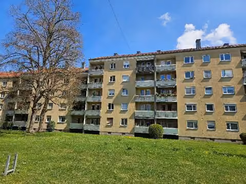 Zwangsversteigerung Eigentumswohnung in Augsburg, Hochzoll – Rückansicht des Gebäudes mit Balkonen und angrenzender Grünanlage.