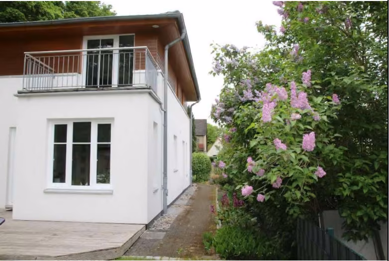 Zwangsversteigerung Einfamilienhaus in Hamburg, Niendorf – Seitenansicht mit Zuwegung und Blick auf den rückwärtigen Balkon.