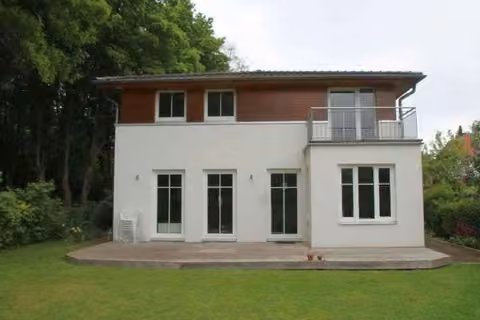 Zwangsversteigerung Einfamilienhaus in Hamburg, Niendorf – Rückwärtige Gebäudeansicht mit Garten und vorgelagerter Terrasse.
