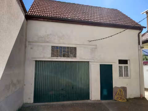 Zwangsversteigerung Zweifamilienhaus in Albertshofen – Rückseitige Ansicht des Wohnhauses mit Flachdachanbau und Freisitz von Nordosten.