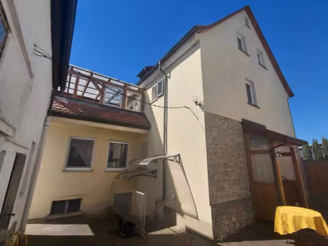 Zwangsversteigerung Zweifamilienhaus in Albertshofen – Westansicht des separaten Garagen- und Nebengebäudes mit Rolltor.