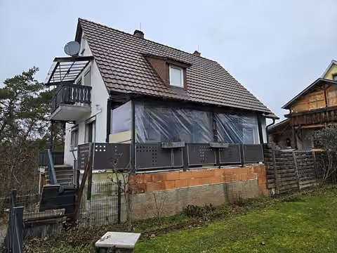 Zwangsversteigerung in Grub am Forst – Außenansicht des Wohnhauses von der Südostseite mit Garten und überdachter Terrasse.