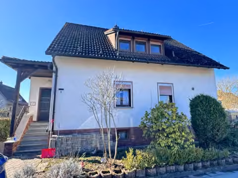 Zwangsversteigerung in Neustadt bei Coburg, Wildenheid – Vorderansicht des Zweifamilienhauses mit Dachgaube und Hauseingang.