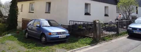 Zwangsversteigerung in Nordhalben – Blick auf das Einfamilienhaus von Süd-Westen mit Hofeinfahrt und Garage.
