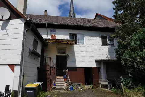 Zwangsversteigerung Einfamilienhaus in Münchhausen, Niederasphe – Hofansicht des Gebäudes von Süden mit Eingangstreppe.