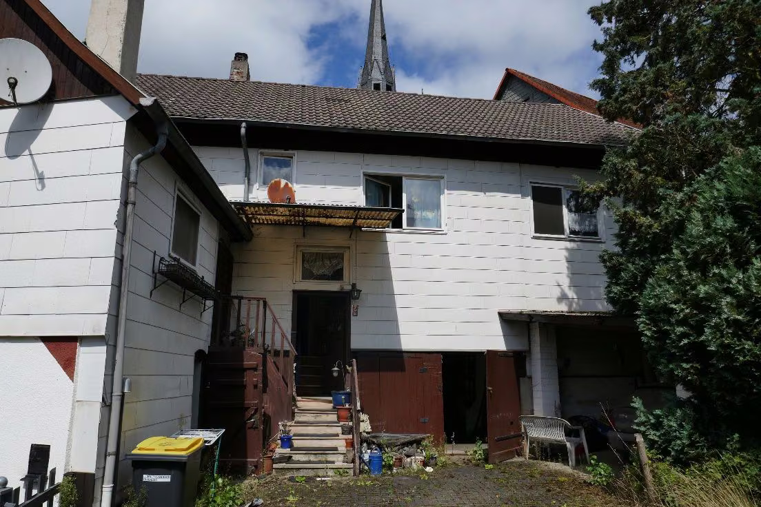 Zwangsversteigerung Einfamilienhaus in Münchhausen, Niederasphe – Hofansicht des Gebäudes von Süden mit Eingangstreppe.