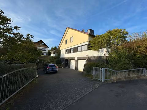 Zwangsversteigerung Einfamilienhaus in Marburg, Bauerbach – Südwestansicht des Einfamilienhauses mit Zufahrt und Vorgarten.