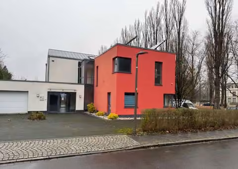Zwangsversteigerung Einfamilienhaus in Dortmund, Innenstadt Ost – Straßenansicht des modernen Einfamilienhauses mit Vorplatz und rotem Baukörper.