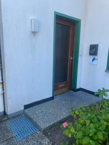 Zwangsversteigerung Einfamilienhaus in Lage – Vorderansicht des Einfamilienhauses von Norden mit Eingangsbereich und Vorgarten.