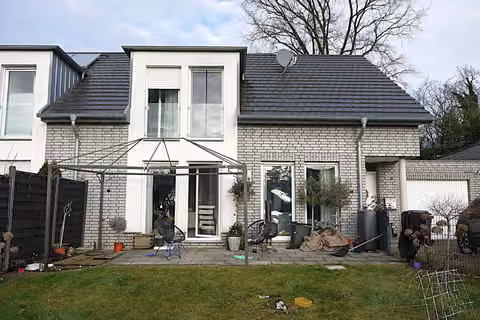 Zwangsversteigerung Doppelhaushälfte in Bielefeld, Sennestadt – Vorderansicht der Doppelhaushälfte mit Hauseingang und Zufahrt zur Garage.