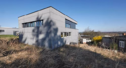 Zwangsversteigerung Wohn-/Geschäftshaus in Waldesch – Rückansicht des freistehenden Gewerbekomplexes.