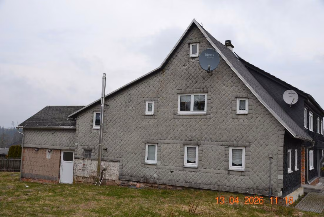 Zwangsversteigerung Einfamilienhaus in Föritztal, Neuenbau – Giebelansicht des Wohnhauses aus südlicher Richtung mit Asbestplattenverkleidung.