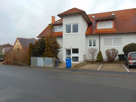 Zwangsversteigerung Eigentumswohnung in Hettstadt – Südostansicht des Wohngebäudes mit Fensterbereichen der Dachgeschosswohnung.