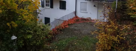 Zwangsversteigerung Eigentumswohnung in Heiligenstadt – Außenansicht des freistehenden Wohngebäudes in Hanglage mit Gaube und Terrassenzugang