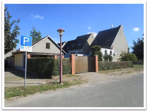 Zwangsversteigerung Einfamilienhaus in Friesack – Straßenansicht des Grundstücks von der Straße Wiesengrund mit Nebengebäude.