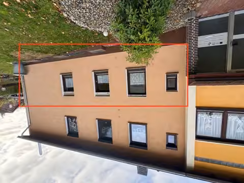 Zwangsversteigerung Eigentumswohnung in Homberg (Efze) – Außenansicht des Mehrfamilienhauses mit rot markierter Lage der Erdgeschosswohnung.