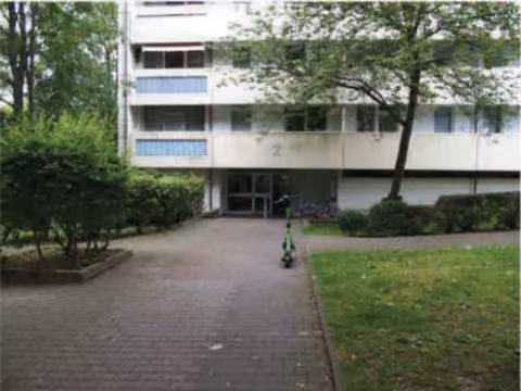 Zwangsversteigerung Eigentumswohnung in Frankfurt am Main, Bonames – Hauseingangsbereich und untere Fassade des Mehrfamilienhauses Julius-Brecht-Straße 2.