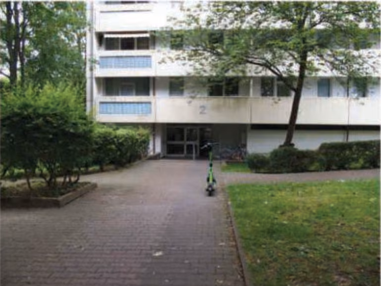 Zwangsversteigerung Eigentumswohnung in Frankfurt am Main, Bonames – Hauseingangsbereich und untere Fassade des Mehrfamilienhauses Julius-Brecht-Straße 2.