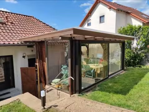 Zwangsversteigerung Einfamilienhaus in Gelnhausen, Roth – Detailansicht des Wintergartens mit großen Glasschiebeelementen.